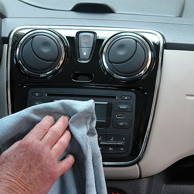 Mobile car wash and auto detailing picture of wiping a car radio.