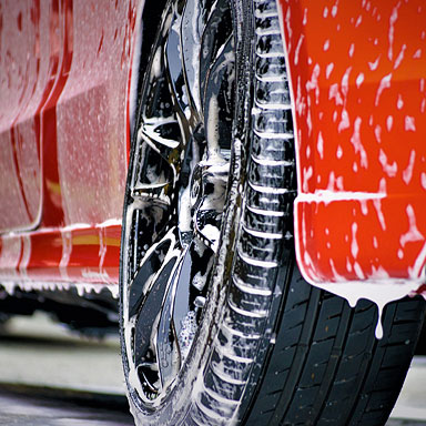 Mobile car wash and auto detailing picture of a red car with soap on it.